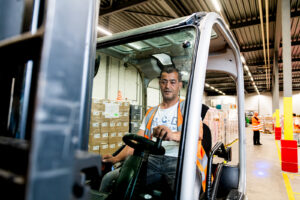 Een medewerker van het magazijn aan het werk op de heftruck.